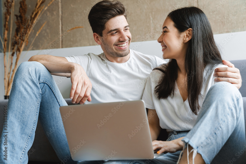 Loving couple at home on floor using laptop computer Loving couple at home on floor using laptop computer