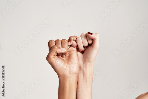 Quadro em tela Close up of two female hands making a pinkie promise sign isolated over grey background