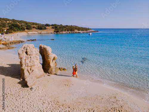 Tropical beach of Voulisma beach, Istron, Crete, Greece ,Most beautiful beaches of Crete island -Istron bay near Agios Nikolaos drone aerial view, couple walking on the ebach photo