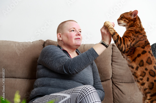 Woman playing with cat on sofa photo