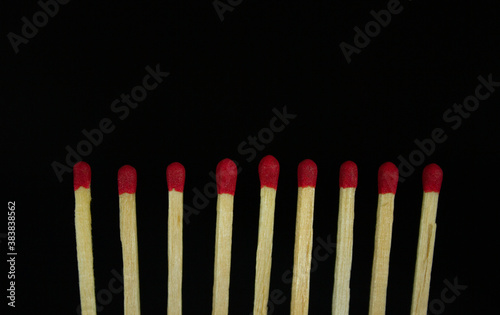 close up row of red matches isolated on black background with copy space.