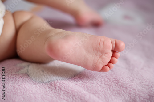Baby's foot on a pink blanket. Close up