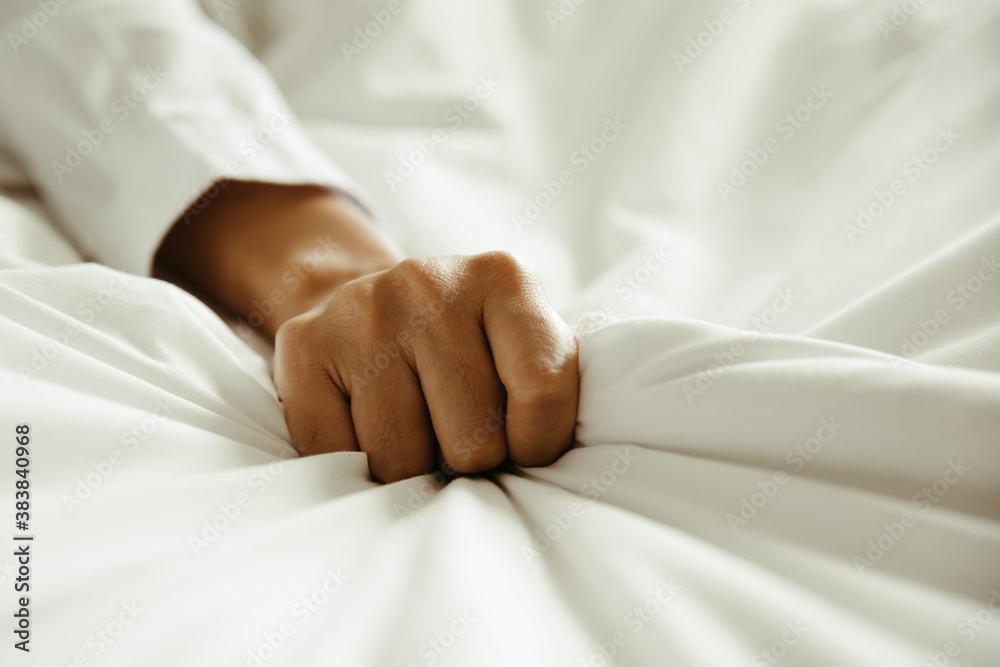 Close up hand of female pulling white sheets in ecstasy , feeling and emotion concept Close up hand of female pulling white sheets in ecstasy , feeling and emotion concept