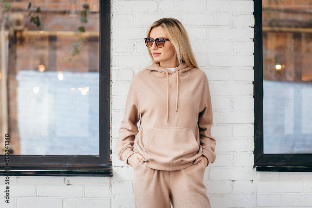 Young woman in glasses and hoodie - obrazy, fototapety, plakaty 