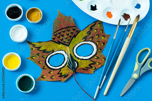 Owl mask painted on maple leaf