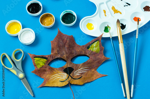 Cat mask painted on maple leaf