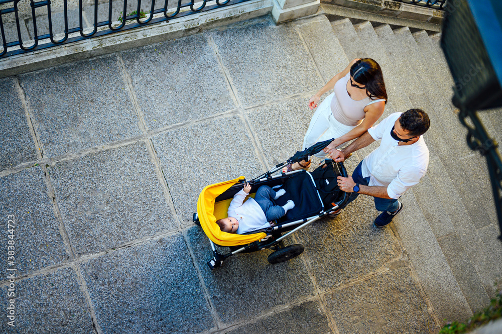 happy couple walking with baby carriage. baby. newborn happy couple walking with baby carriage. baby. newborn