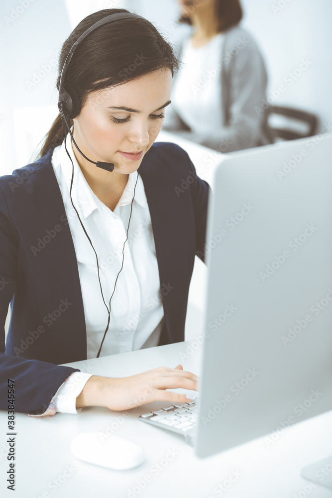 Call center. Beautiful woman sitting and working in headset at customer service office. Business concept Call center. Beautiful woman sitting and working in headset at customer service office. Business concept
