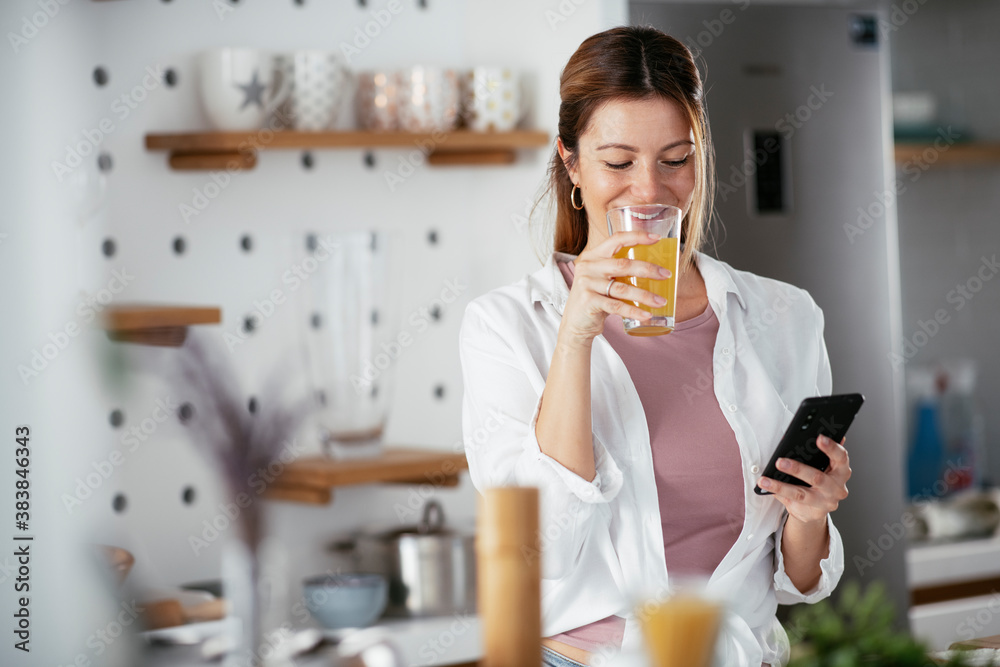 Young woman in kitchen. Beautiful woman preparing breakfast and drinking juice. Young woman in kitchen. Beautiful woman preparing breakfast and drinking juice.