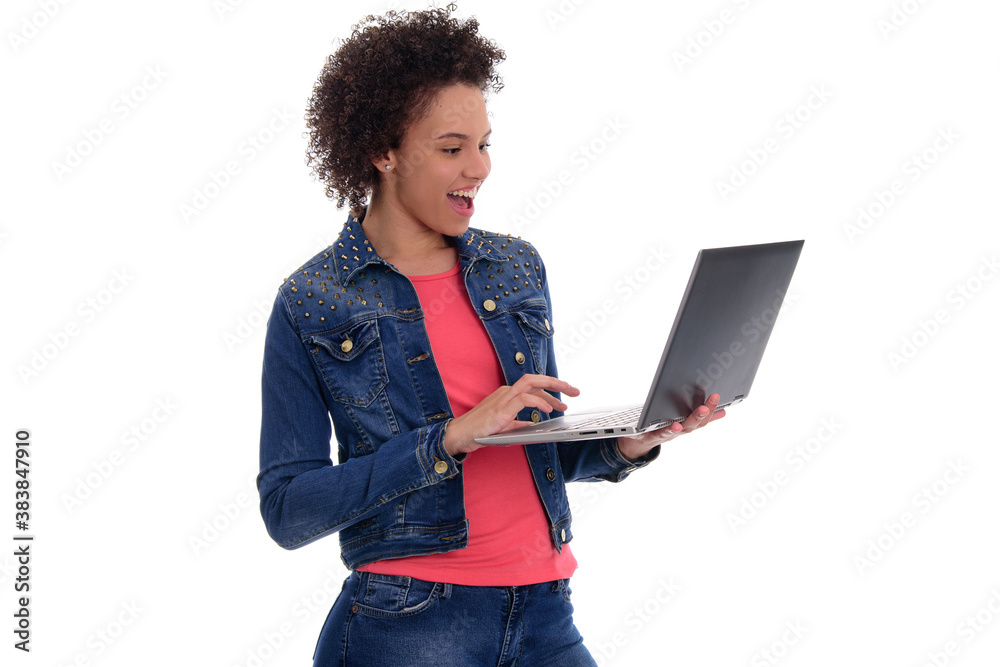 Happy young Brazilian woman wearing a jacket and holding laptop with surprised expression isolated on white background Happy young Brazilian woman wearing a jacket and holding laptop with surprised expression isolated on white background
