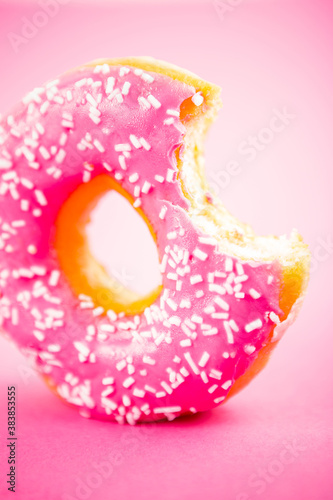 Studio shot of a colorful donut on pink background.