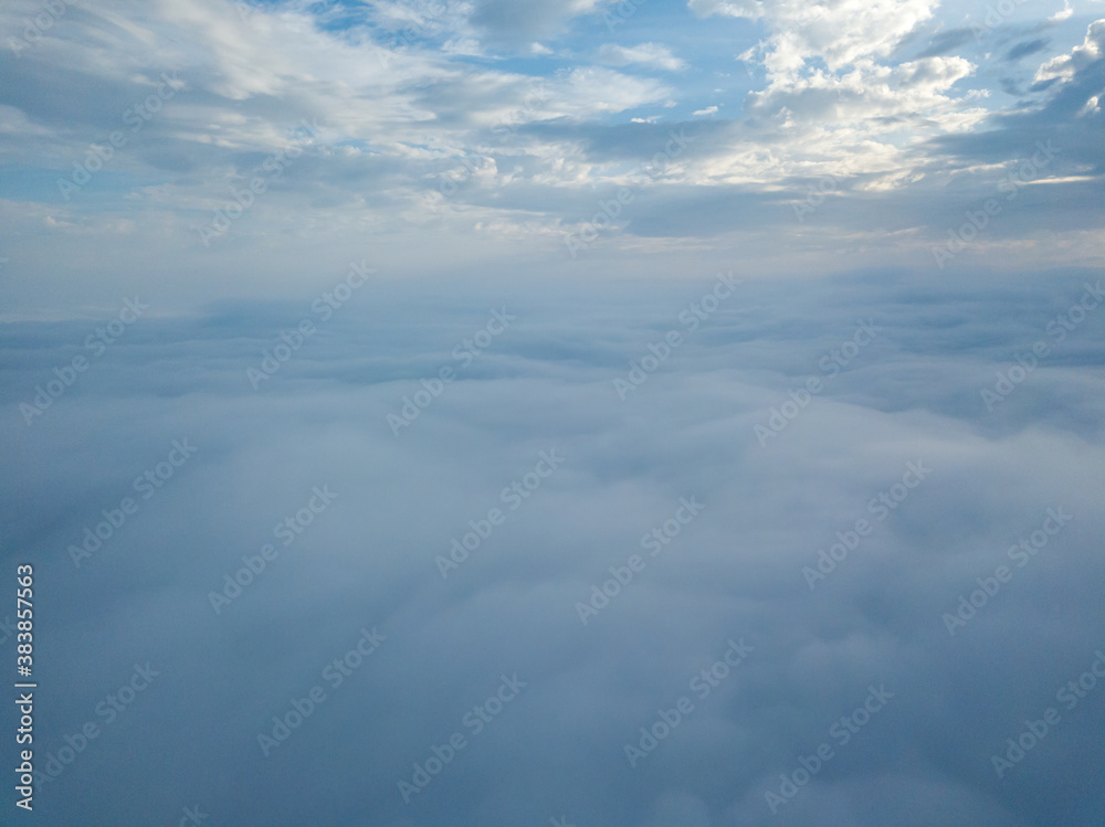 Aerial drone flight over the fog. There are thick clouds of fog below, cloudy.