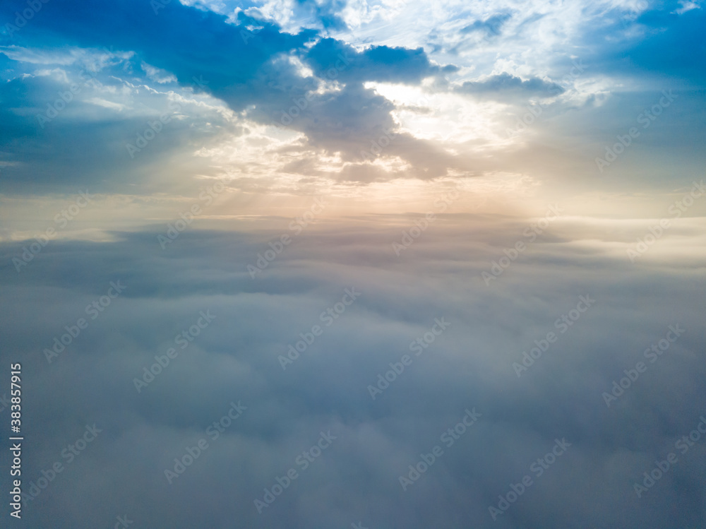 Aerial drone flight over the fog. There are thick clouds of fog below, the sun breaks through the clouds. Aerial drone flight over the fog. There are thick clouds of fog below, the sun breaks through the clouds.