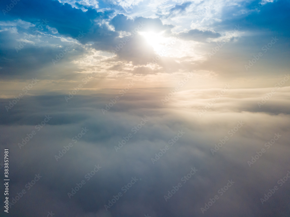 Aerial drone flight over the fog. There are thick clouds of fog below, the sun breaks through the clouds. Aerial drone flight over the fog. There are thick clouds of fog below, the sun breaks through the clouds.
