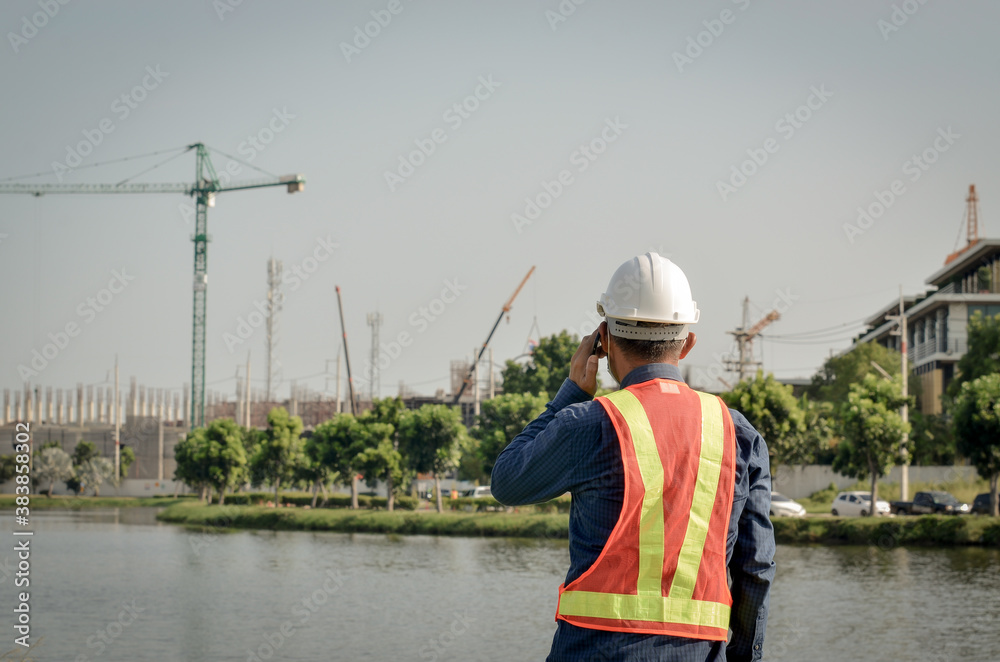 Engineer using a mobile phone to contact the job on working site Engineer using a mobile phone to contact the job on working site