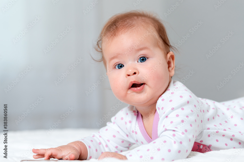 Close-up portrait of a happy baby lying on the bed. Copy space. The concept of parenthood and family planning Close-up portrait of a happy baby lying on the bed. Copy space. The concept of parenthood and family planning