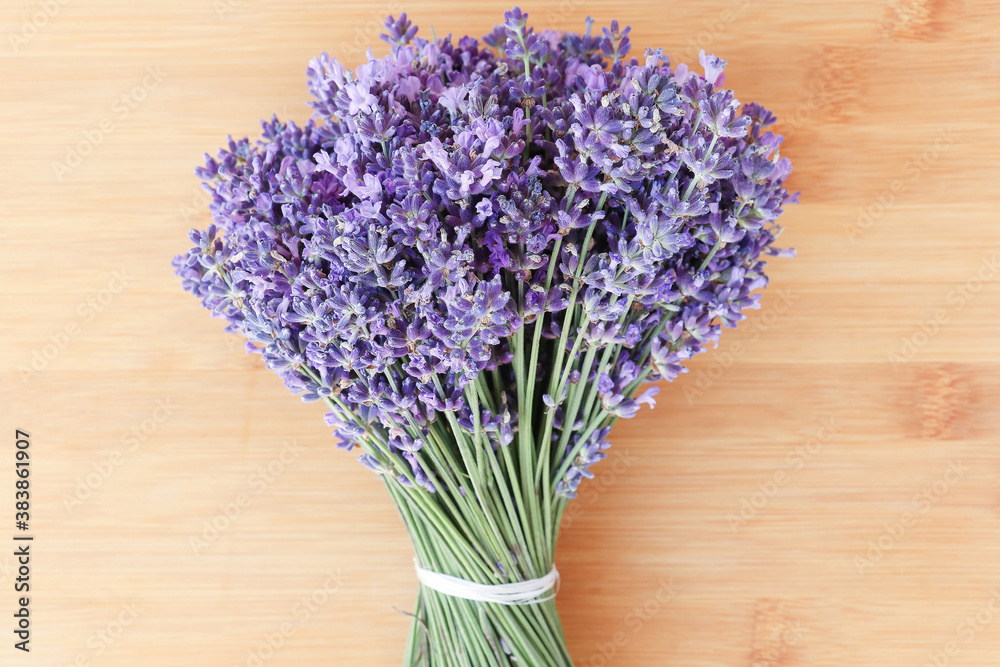 Fototapeta premium A bouquet of lavender on a wooden background. Fresh flower. Dark lilac and blue flowers of lavender.