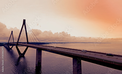 Large highway bridge with traffic passing over a bay at sunset. photo