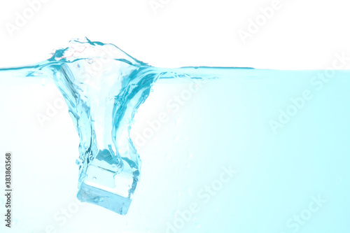 Throw ice into the water making a clear blue splash water wave, isolated on a white background. with copy space © VRVIRUS