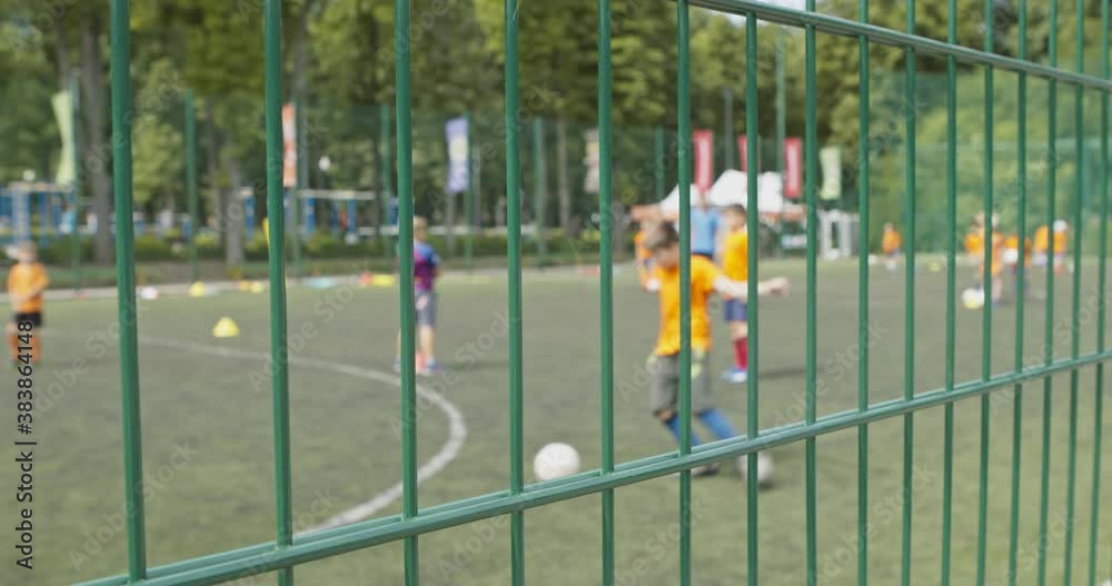 Selective focused shot of outdoor football court and kids playing soccer Selective focused shot of outdoor football court and kids playing soccer