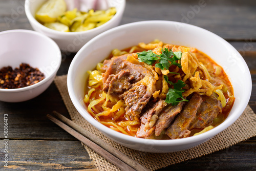 Northern Thai food (Khao Soi), Spicy curry noodles soup with beef eating with pickled mustard, shallot, lime and ground chili fried in oil