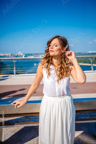 a girl in a white dress walks on a bridge in kiev
