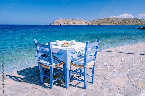 Crete Greece Plaka Lassithi with is traditional blue table and chairs and the beach in Crete Greece. Paralia Plakas, Plaka village Crete photo