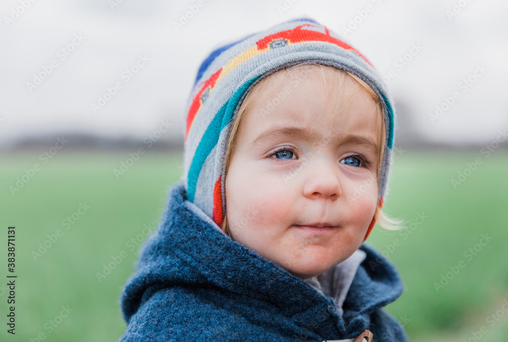 Portrait of toddler girl with warm clothing in front of field Portrait of toddler girl with warm clothing in front of field