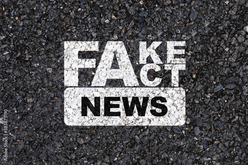 White Fake and Fact news print screen on asphalt concrete road background.