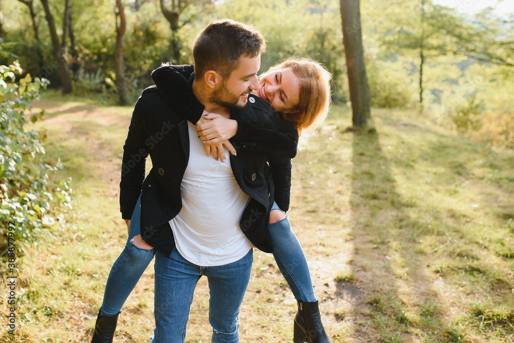 love, relationship, family and people concept - smiling couple having fun in autumn park