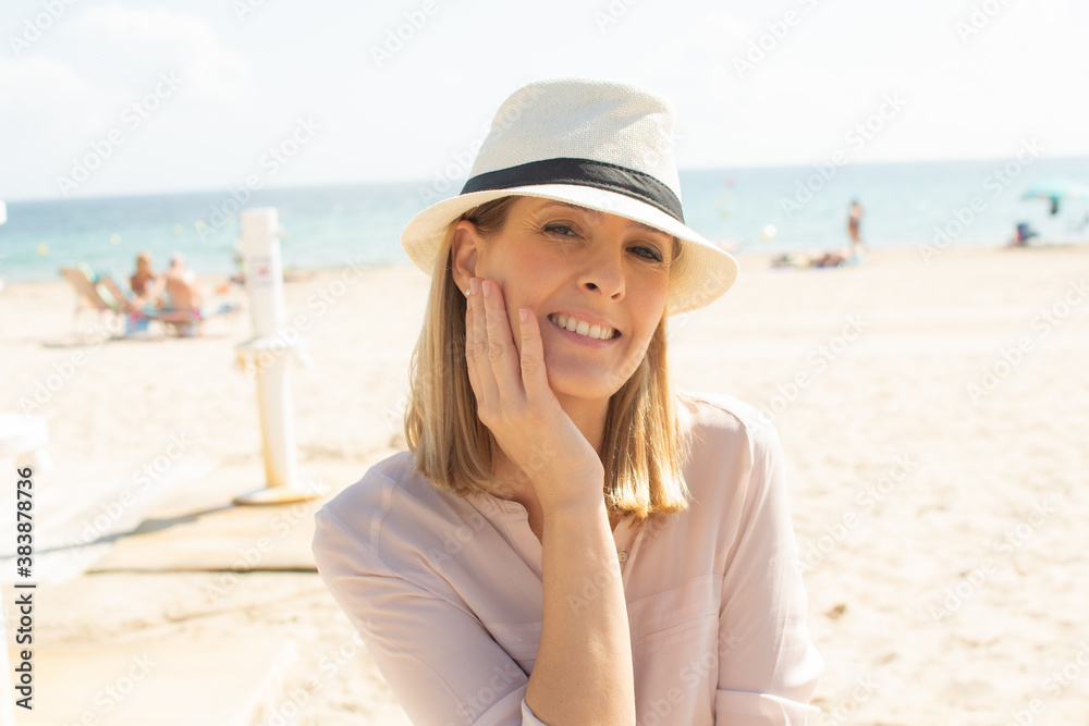Photo of fashionable woman wearing white hat smiling to camera. Photo of fashionable woman wearing white hat smiling to camera.