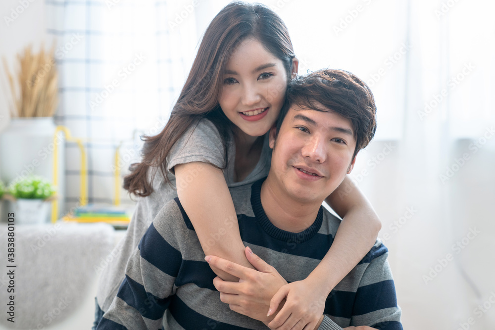 Happy young Asian couple hugging and smiling sitting on the bed in a bedroom at home. Happy young Asian couple hugging and smiling sitting on the bed in a bedroom at home.