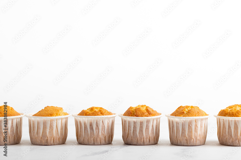Fresh yellow muffins closeup on the white background Fresh yellow muffins closeup on the white background