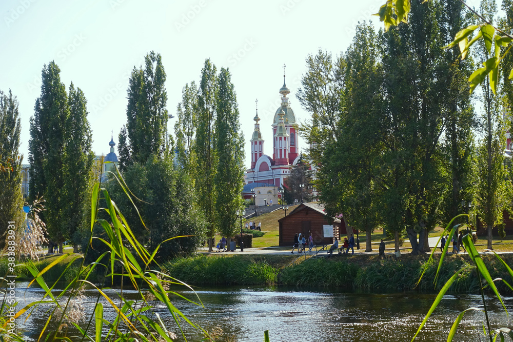 Fototapeta premium View of the Tamblva embankment and the bell tower of the Kazan monastery Tambov from the bank of the Tsna river on a summer day