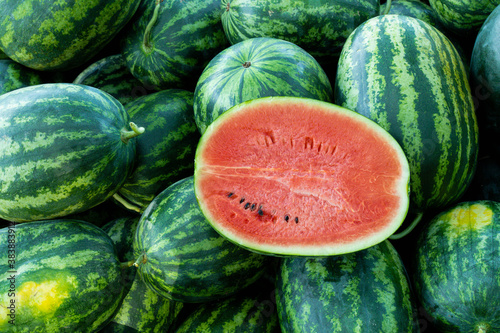 Half watermelon one pice on lot of water melons, Healthy eating. Lots of juicy and ripe watermelons.