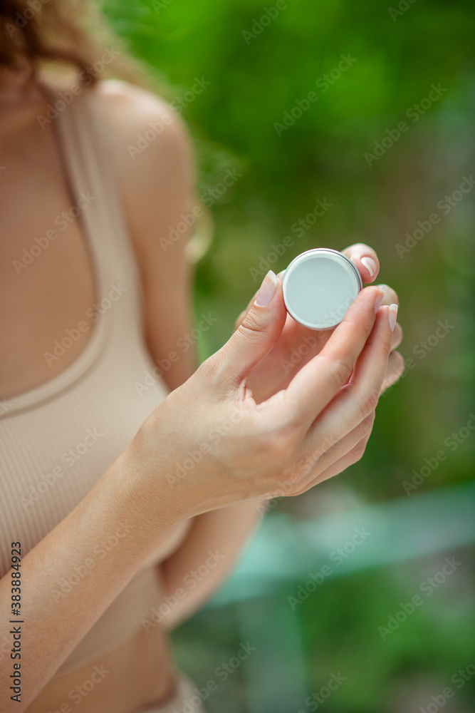 Close up of womns hands holding lip balm