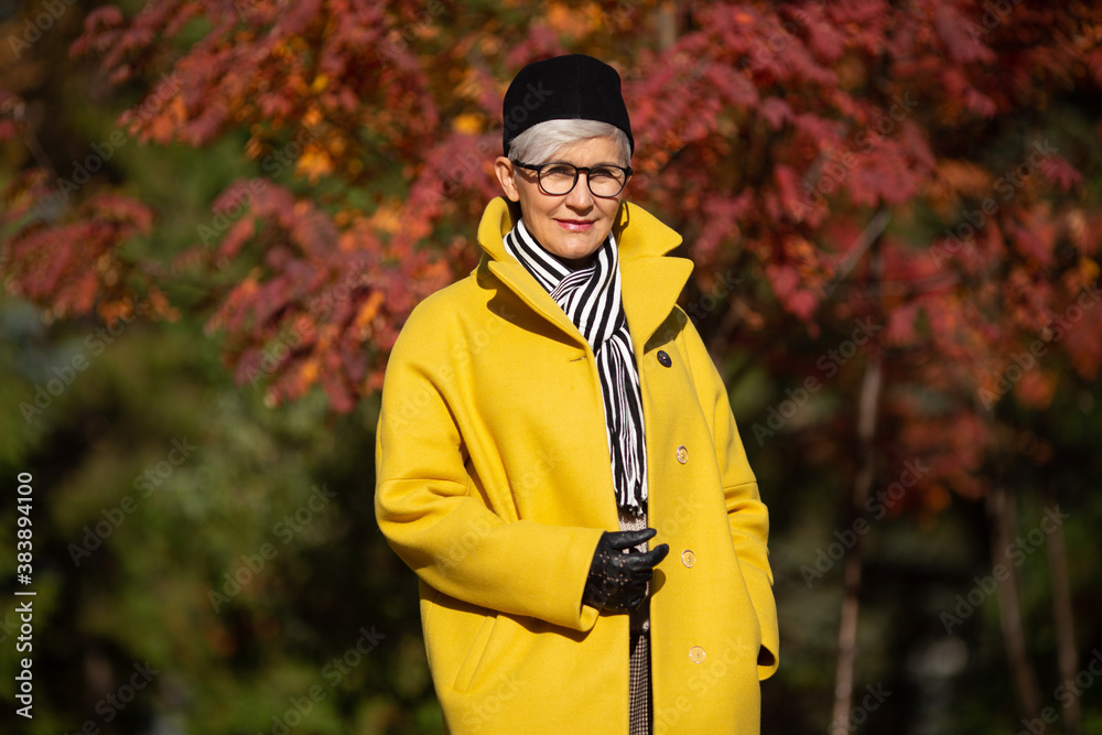 adult woman in yellow coat in the park in autumn