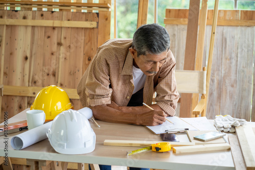 senior Asian man working on wood  work home improvement DIY in workshop recoding streaming online