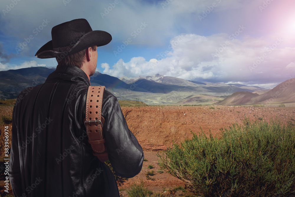 Cowboy looks into the distance at the mountains. Western culture. Cowboy looks into the distance at the mountains. Western culture.
