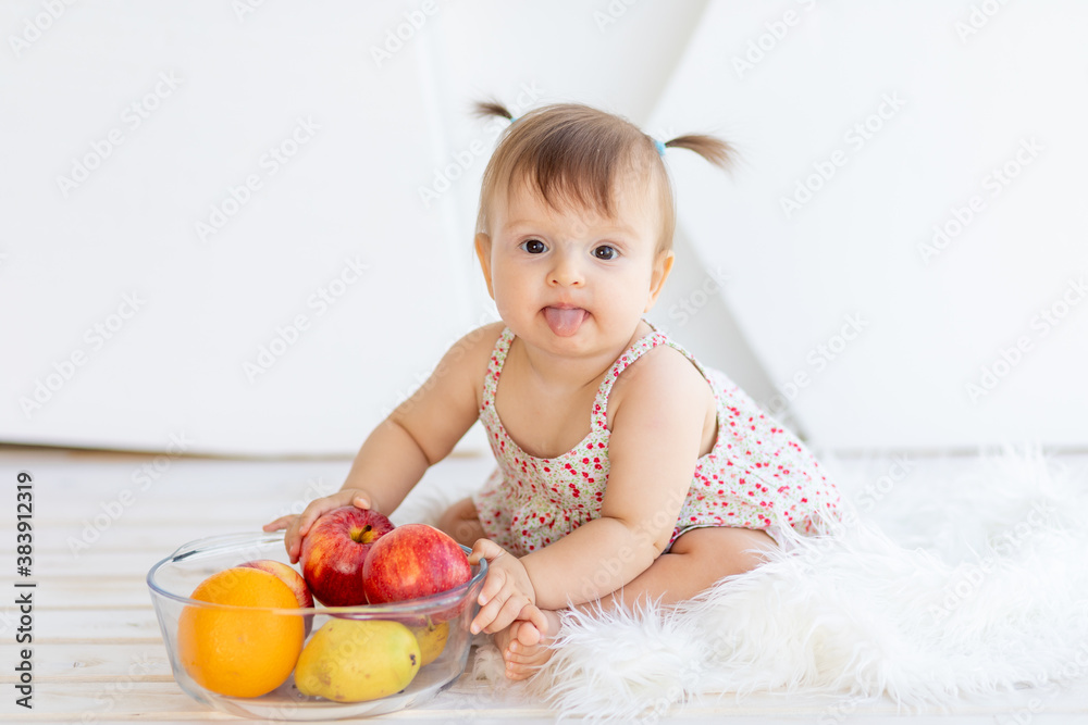 a little girl in a bright room sitting with a plate of fruit a little girl in a bright room sitting with a plate of fruit