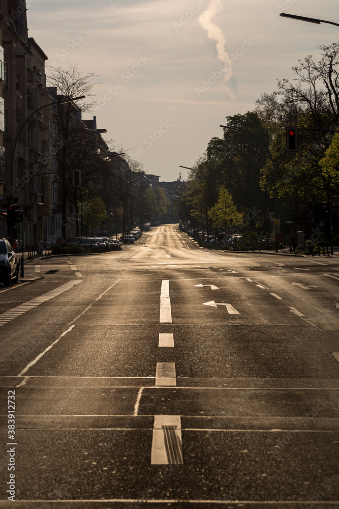 Vertical early morning scene of empty street known as Kreuzbergstrasse in the neighborhood of Kreuzberg, in Berlin, Germany. POV standing in the middle of empty street, diminishing perspective view