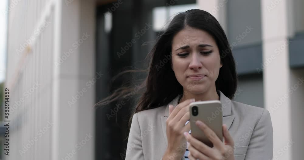 Close up portrait of beautiful unwell Caucasian woman standing in city and coughing while tapping on smartphone. Sick young female worker outdoors having cold and texting on cellphone. Virus concept Close up portrait of beautiful unwell Caucasian woman standing in city and coughing while tapping on smartphone. Sick young female worker outdoors having cold and texting on cellphone. Virus concept