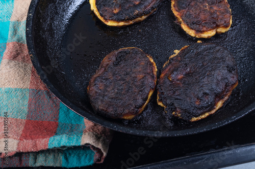 electric stove. Induction. There is a frying pan with food on it. The food is burnt. photo