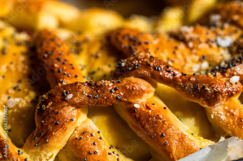 Close up photo with selective focus on details of salt and poppy seeds over a braided puff pastry. photo