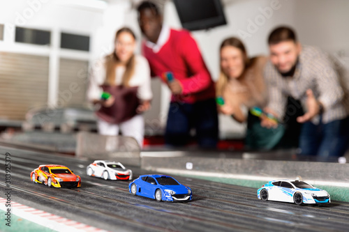 Toy remote control racing bright colorful multicolored cars on the track and enthusiastic players