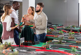 Friends discuss game results on toy slot racing car track. High quality photo