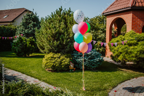 Bunch of colourful balloons in the garden. Birthday decoration.
