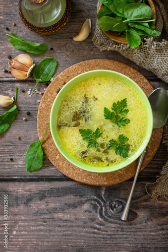 Spinach soup with cream on a rustic wooden table. Top view flat lay background. Copy space.