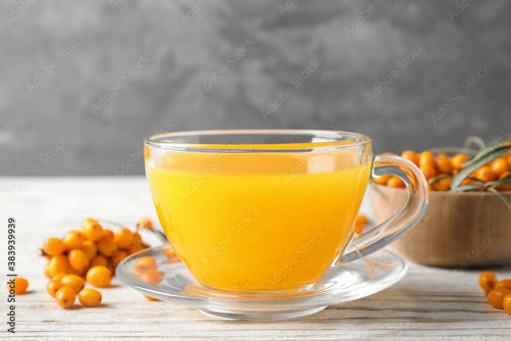 Fresh sea buckthorn tea on white wooden table, closeup Fresh sea buckthorn tea on white wooden table, closeup