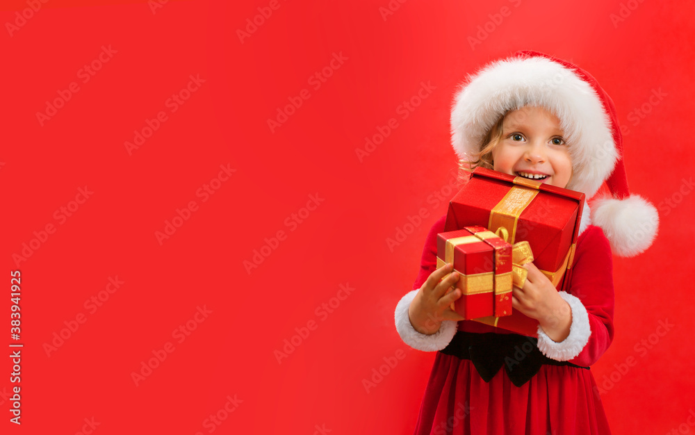 Smiling funny child in Santa red hat holding Christmas gift in hand. Smiling funny child in Santa red hat holding Christmas gift in hand.